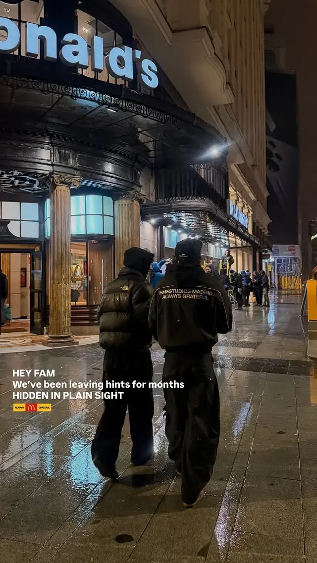 Dos personas de espaldas caminan de noche por Madrid; una lleva una chaqueta negra con Emestudios Madrid Always Grateful