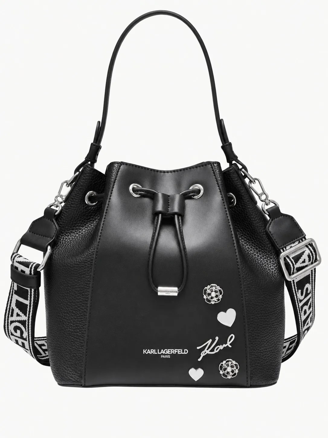 Bolso bucket Karl Lagerfeld negro, vista frontal con cierre de cordón, apliques plateados de corazones y la firma Karl y correa con el logo en blanco y negro