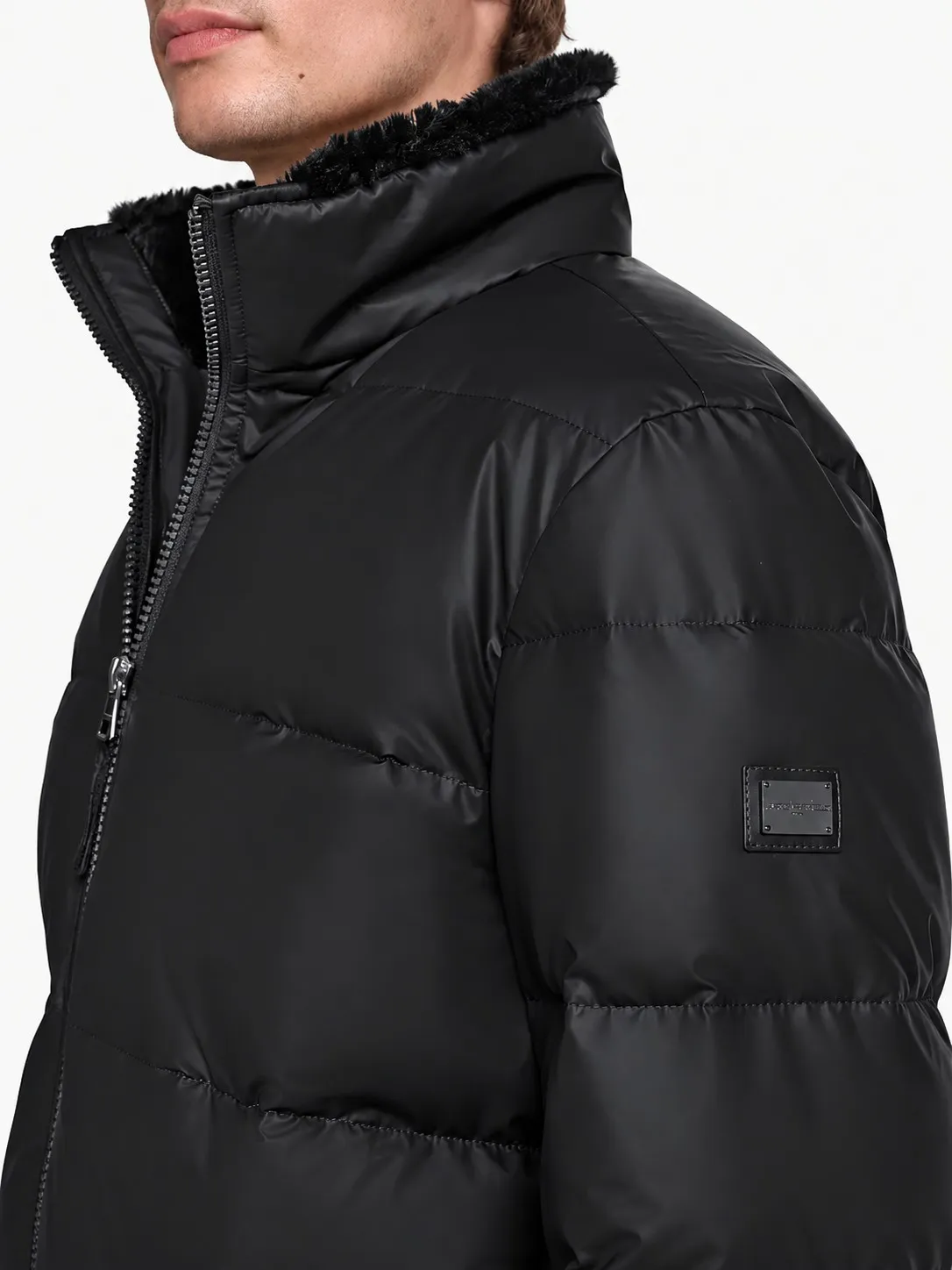 Chaqueta bomber Karl Lagerfeld negra puesta, detalle del cuello de sherpa y la placa con el logo en la manga