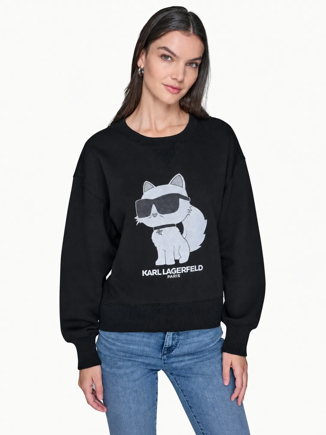 Buzo Karl Lagerfeld negro con Choupette puesto, plano medio de una modelo que lo lleva con jean azul